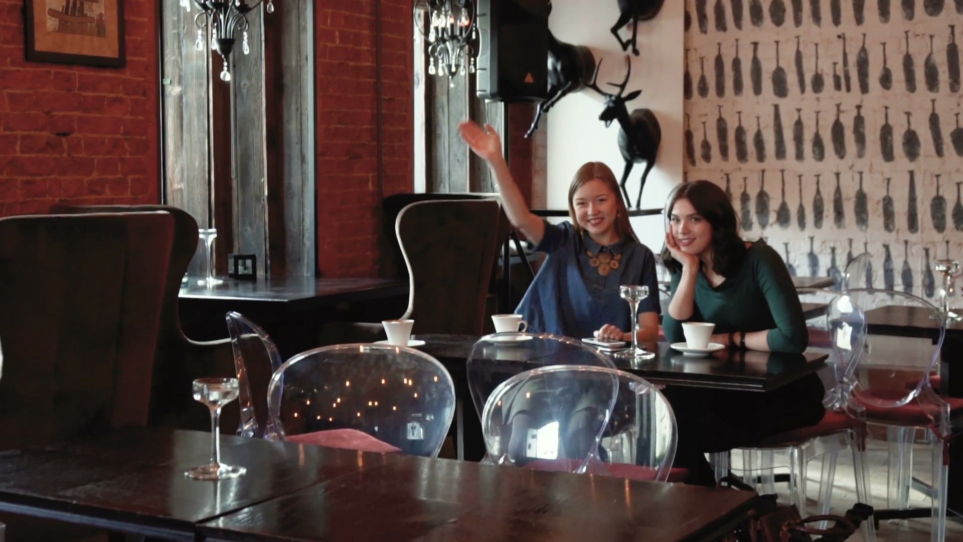 Två glada tjejer som sitter på en servering.